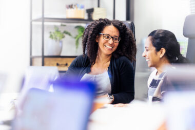 Two women talking in an office in London in a photograph taken by corporate photographer Richard Boll.