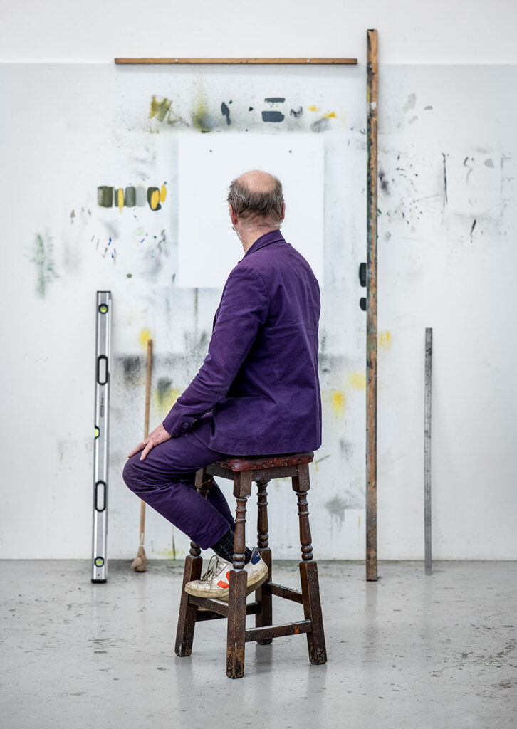 Portrait of the artist Gavin Turk facing away from the camera in his London studio. Photo by Richard Boll.