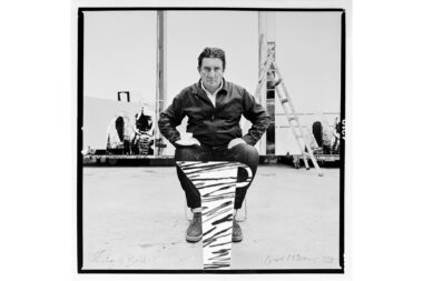 A black and white portrait of the sculptor and painter Bruce McLean in his studio in London with a hand-painted jug applied by Bruce McLean.