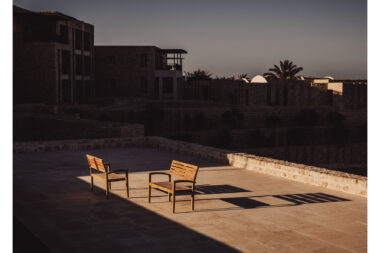 Two benches in a patch of evening sunlight at Wadi Sabarah Lodge taken by lifestyle photographer RIchard Boll.