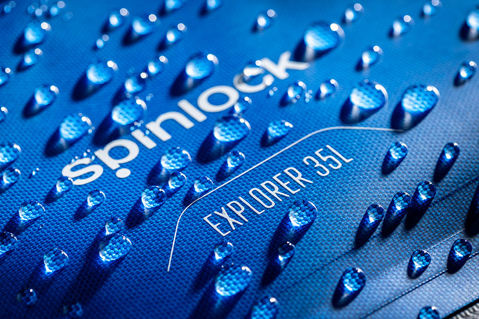 Studio product photography of close up detail of water droplets on a waterproof bag made by Spinlock.